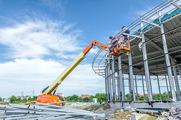 High elevated cherry picker people are working at new assembled canopies on construction site.